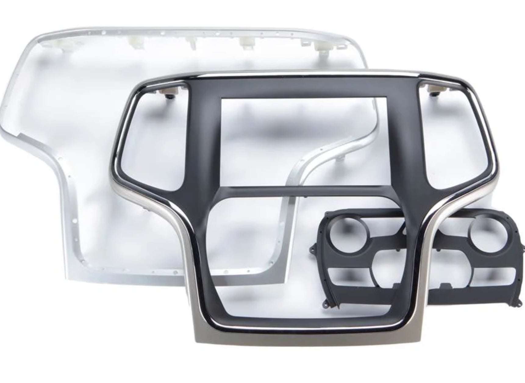 iDatalink KIT-JGC1 included dash components showing large silver and black Jeep Grand Cherokee radio surround bezel, inner chrome-trimmed head unit bezel, and black dual HVAC knob control module
