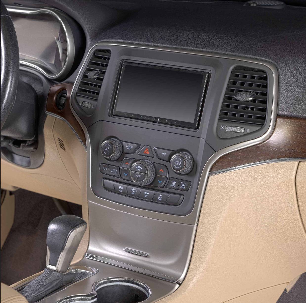 Metra 95-6562 aftermarket double DIN radio installed in Jeep Grand Cherokee center console with factory-matching dash trim and HVAC controls