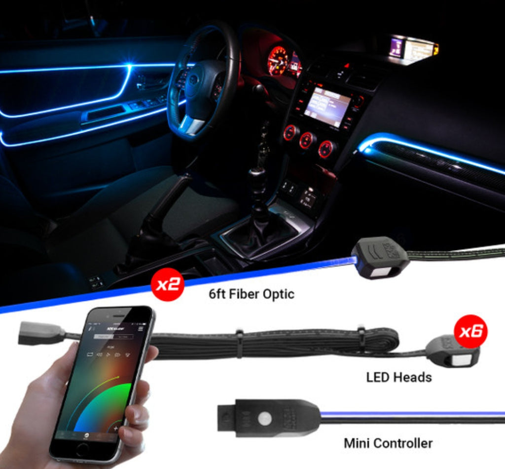 Car interior ambient LED light kit shown installed in a dashboard, with separate components including 6ft fiber optic, LED heads, and a mini controller, plus a hand holding a smartphone app screen.