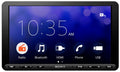 Sony XAV-AX8100 8.95 inch single DIN multimedia receiver front view with screen off showing black bezel, Sony logo, and capacitive touch control buttons